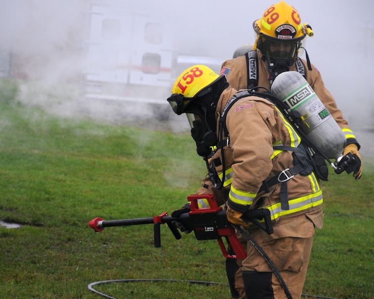 David Ives from March, Cambridgeshire, left, and U.S. Air Force Airman 1st Class Mathew Guajardo from Dallas, Texas, both 100th Civil Engineer Squadron Fire Department firefighters, use a PyroLance during a training exercise Nov. 20, 2013, on RAF Mildenhall, England. Water discharges from a Pyrolance at a rate of 10 gallons per minute, compared to a traditional handline that discharges up to 350 gallons per minute. This greatly reduces water damage to the area affected by the fire. (U.S. Air Force photo by Gina Randall/Released)