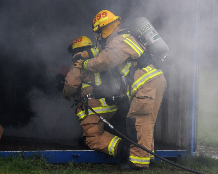David Ives from March, Cambridgeshire, England, left, and U.S. Air Force Airman 1st Class Mathew Guajardo from Dallas, Texas, both 100th Civil Engineer Squadron Fire Department firefighters, use a PyroLance during a training exercise Nov. 20, 2013, at the fire training facility on RAF Mildenhall, England. This new equipment will eliminate flashover and backdraft conditions, making it safer for firefighters to enter a facility or aircraft for search and rescue efforts and finally extinguish the fire. (U.S. Air Force photo by Gina Randall/Released)