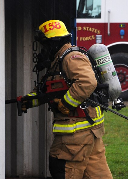 David Ives, 100th Civil Engineer Squadron Fire Department firefighter from March, Cambridgeshire, uses a PyroLance during a training exercise Nov. 20, 2013, at the fire training facility on RAF Mildenhall, England. With this new equipment, one firefighter with a PyroLance can begin extinguishing actions without endangering himself or herself by entering the fire. (U.S. Air Force photo by Gina Randall/Released)