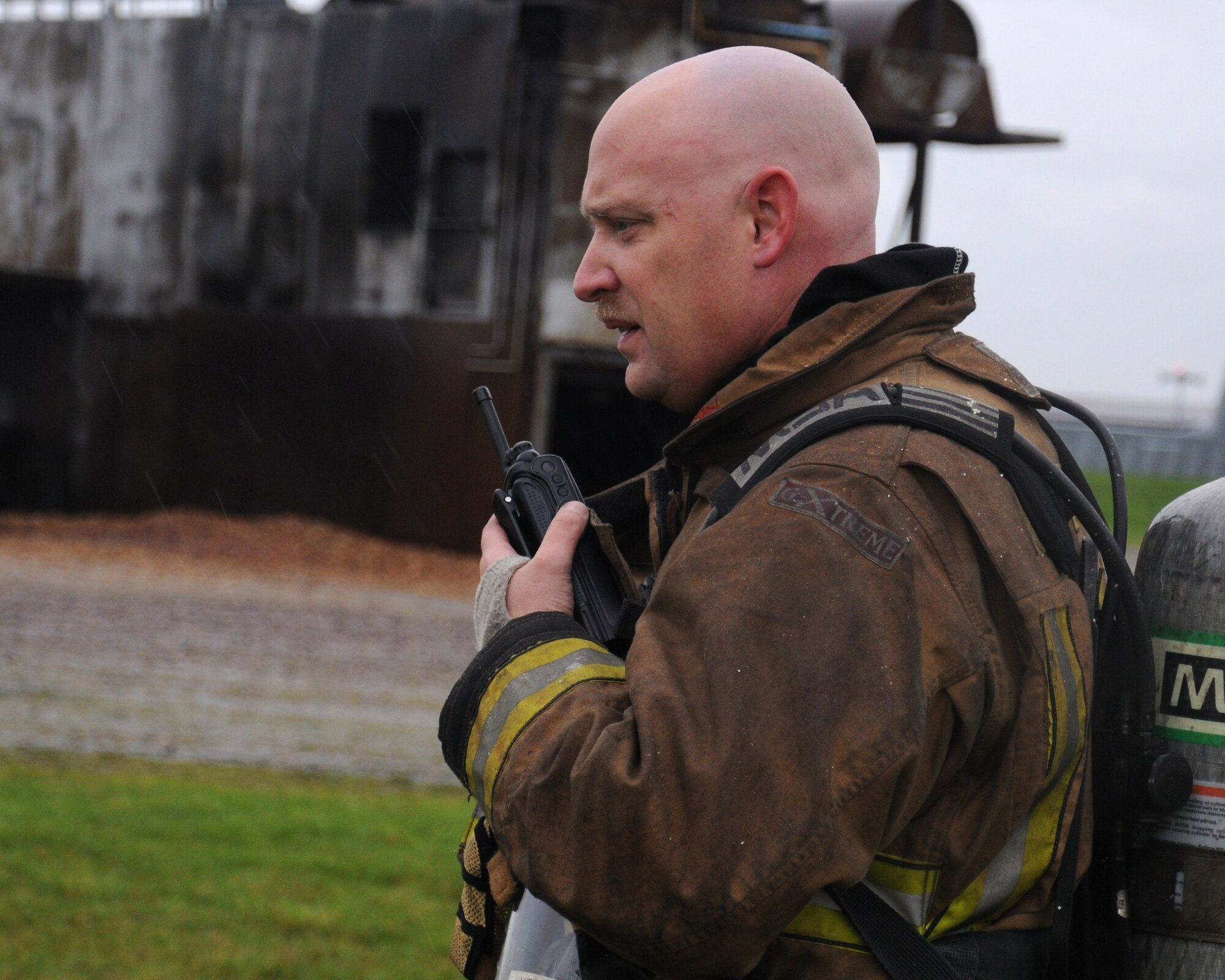 U.S. Air Force Master Sgt. Matthew Luetkemeyer, 100th Civil Engineer Squadron Fire Department assistant chief of fire training from Warrenton, Mo., coordinates a training exercise Nov. 20, 2013, at the fire training facility on RAF Mildenhall, England. During the training, firefighters used a PyroLance. This equipment provides the ability to safely and effectively gain access to burning buildings and fires on armored troop transport vehicles. (U.S. Air Force photo by Gina Randall/Released) 