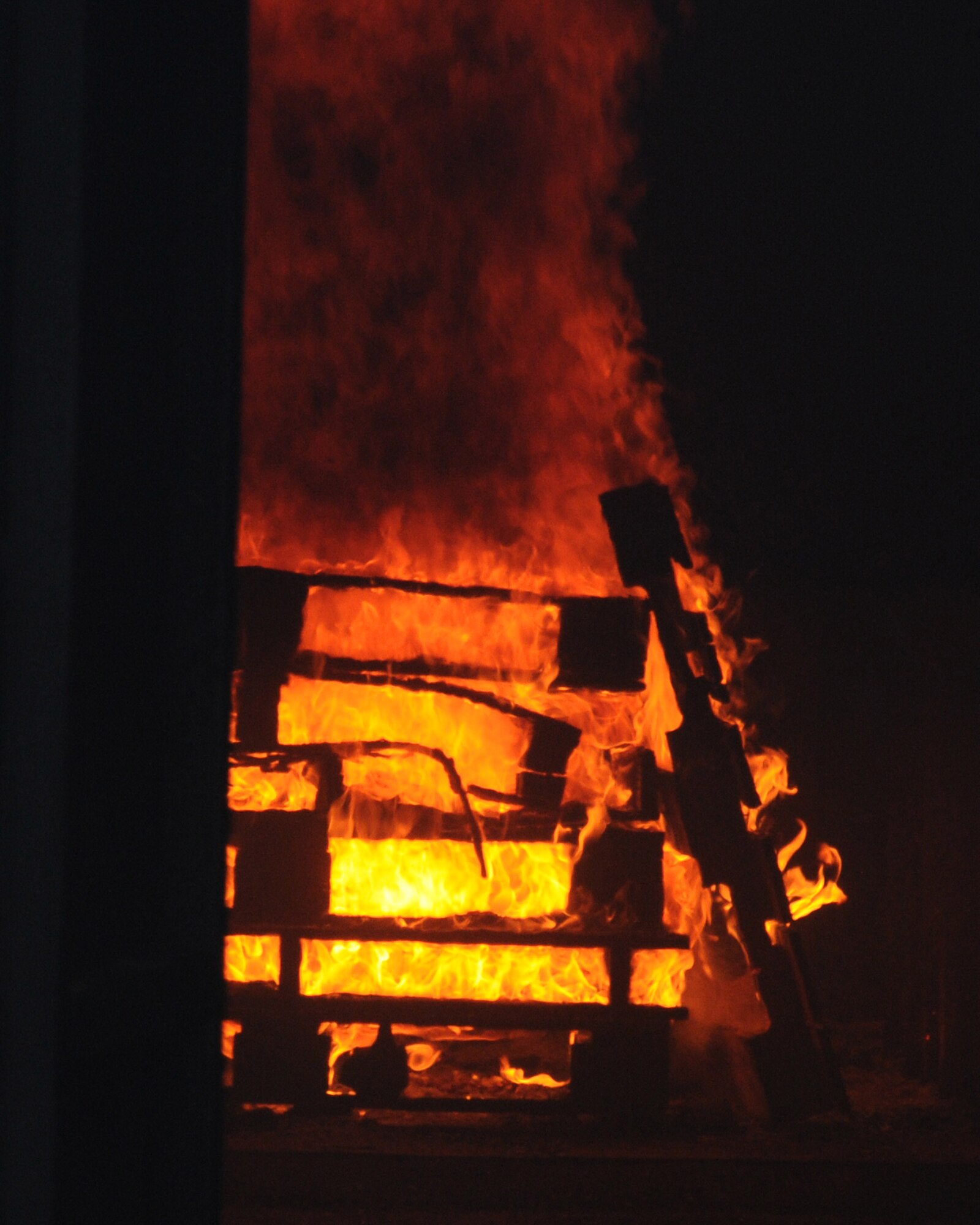 Fire billows from a container during a training exercise Nov. 20, 2013, at the fire training facility on RAF Mildenhall, England. Members of the 100th Civil Engineer Squadron Fire Department used a PyroLance, which provides the capability to penetrate aircraft skins for hidden or hard-to-reach fires. It has a valuable structural firefighting capability when firefighters are faced with compartment fires. (U.S. Air Force photo by Gina Randall/Released) 