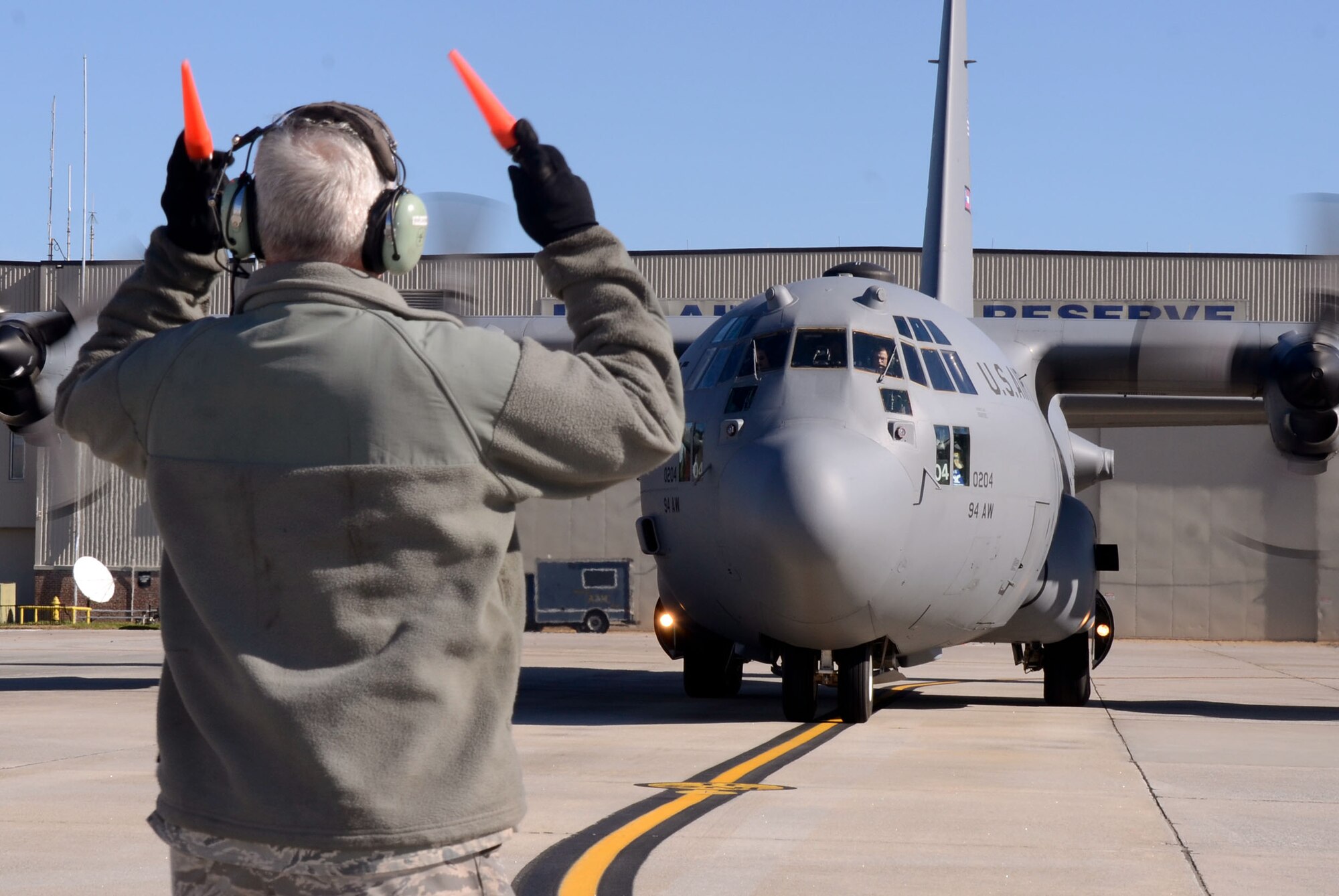 A C-130 Hercules is marshaled into place, as Col. Brett J. Clark, newly assigned 94th Airlift Wing commander, completes his first flight at Dobbins Air Reserve Base, Ga., Nov. 19. Clark is responsible for over 2,500 wing personnel, and the entire installation comprised of 13 tenant units, including 22nd Air Force, Air Force Plant 6 and Lockheed-Martin, Georgia Army and Air National Guard and the Army, Navy and Marine Corps Reserves. (U.S. Air Force photo/Don Peek)