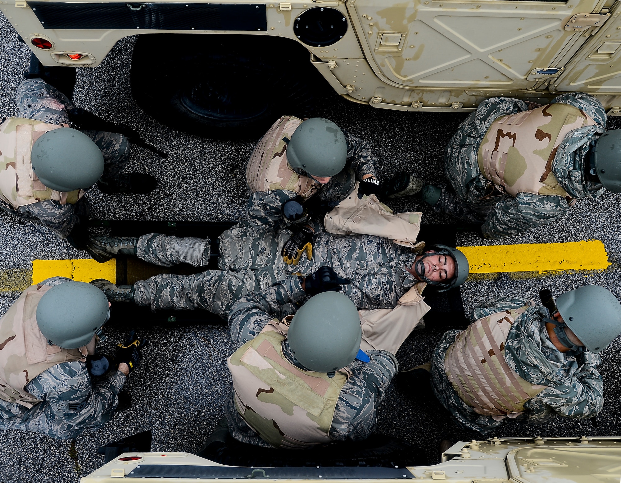 Vehicle operator Airmen from the 6th Logistics Readiness Squadron prepare to carry a litter to the simulated medical evacuation location during convoy training, Nov. 2, 2013 at MacDill Air Force Base, Fla. The training simulated administrating self-aid buddy care (SABC), calling in “9-line medical evacuations,” and helicopter evacuations procedures. (U.S. Air Force photo by Senior Airman Melanie Bulow-Gonterman/Released)  
