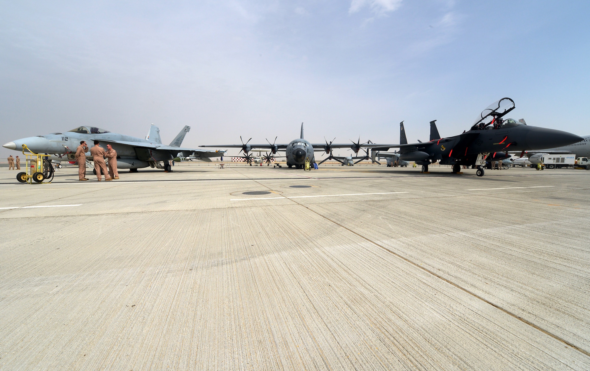 The C-130J Hercules sits centrally between an F-18 Hornet and an F-15E Strike Eagle during the 2013 Dubai Airshow at the Dubai World Central airport in Jebel Ali, United Arab Emirates, Nov. 17, 2013. All Department of Defense assets supporting this year's event were deployed throughout the region. . The C-130J Hercules is deployed from Keesler Air Force Base, Miss. (U.S. Air Force photo/Senior Airman Bahja J. Jones)
