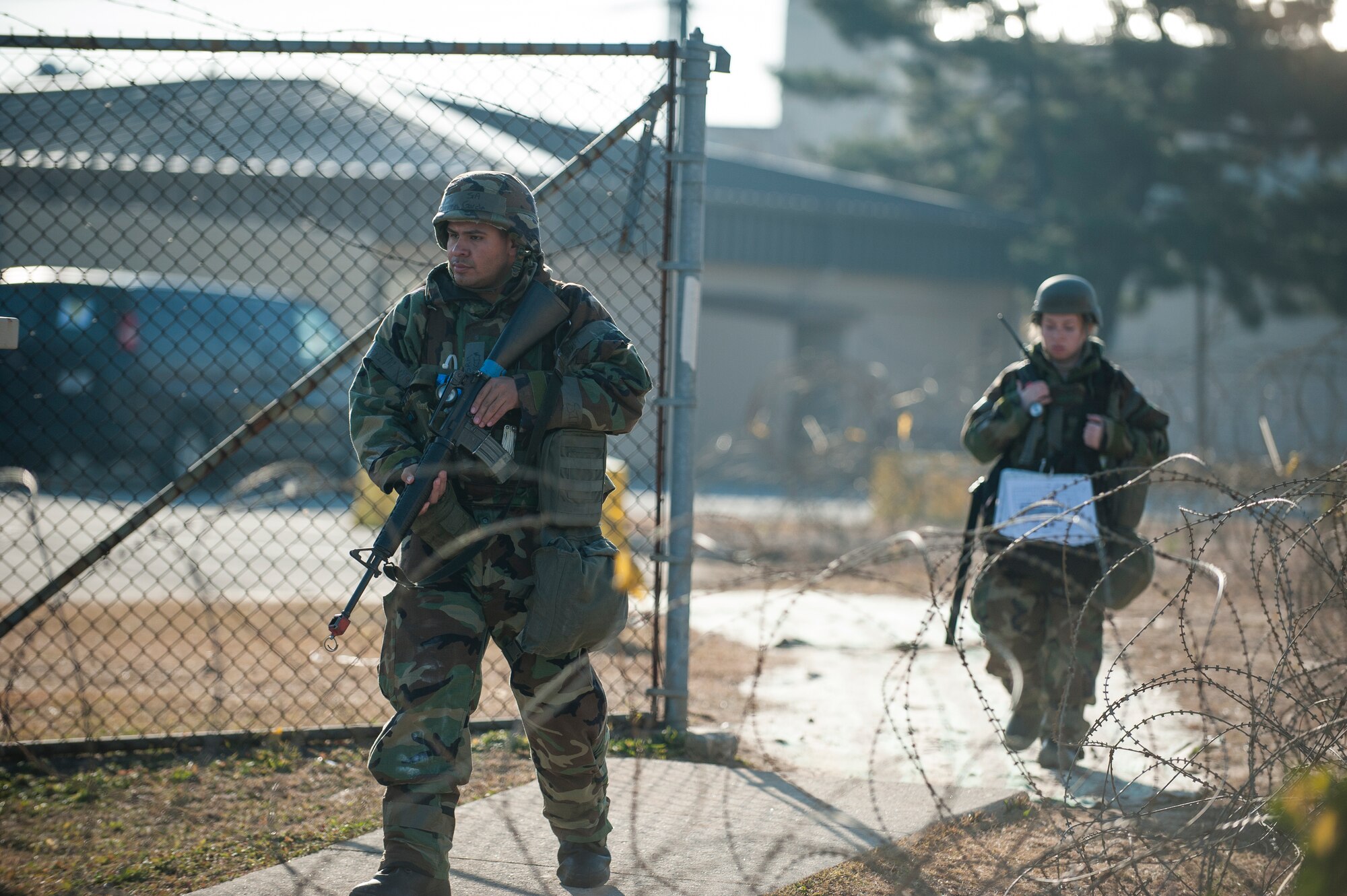 Senior Airmen Matthew Garcia and Kathleen Marco, 8th Communications Squadron, conduct a post attack reconnaissance sweep during exercise Beverly Bulldog 14-01 at Kunsan Air Base, Republic of Korea, Nov. 21, 2013. PAR sweeps are used to identify unexploded ordnance, building damage or other potential hazards following an attack. (U.S. Air Force photo by Senior Airman Clayton Lenhardt/Released)