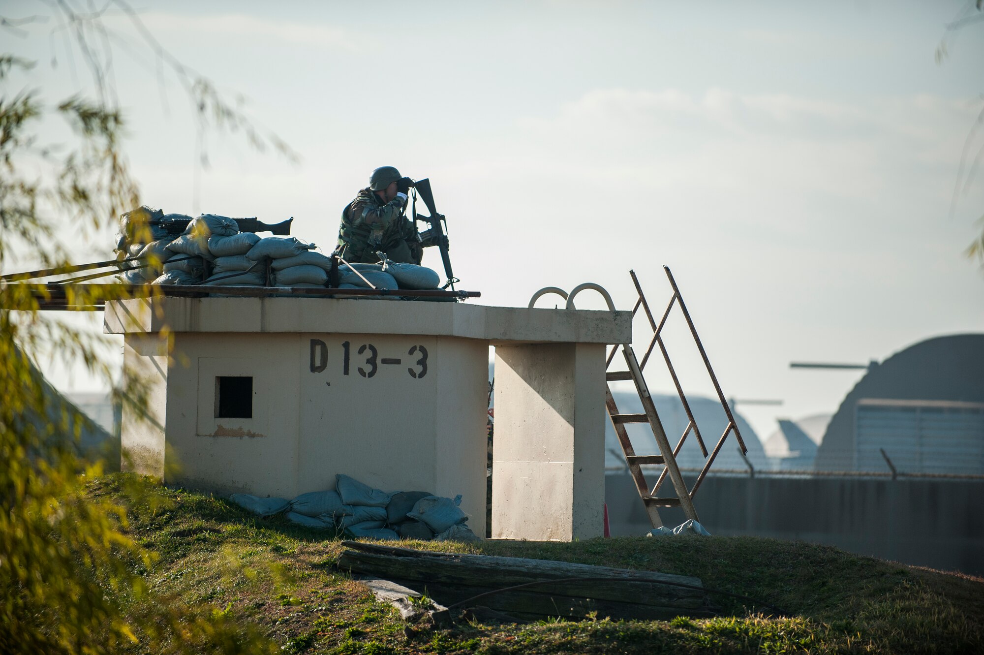 Senior Airman Christopher Stewart, 8th Maintenance Squadron, surveys the area surrounding his defensive fighting position during exercise Beverly Bulldog 14-01 at Kunsan Air Base, Republic of Korea, Nov. 21, 2013. Wolf Pack members from all career fields are trained and tasked as 8th Security Forces Squadron augmentees during wartime. (U.S. Air Force photo by Senior Airman Clayton Lenahrdt/Released)