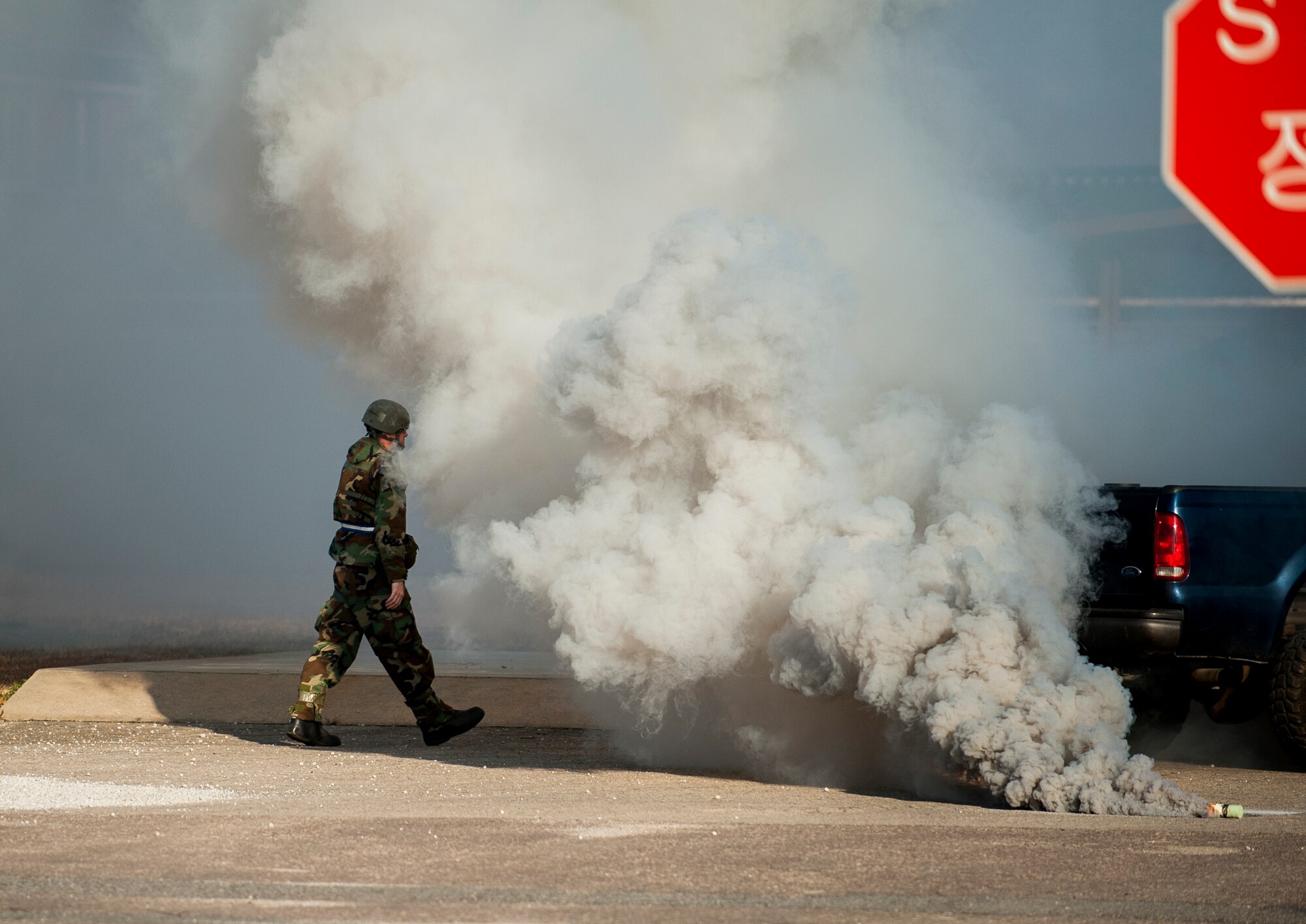 Master Sgt. Mark Dulaney, 8th Fighter Wing Safety, tosses a smoke grenade for added realism in an inject during exercise Beverly Bulldog 14-01 at Kunsan Air Base, Republic of Korea, Nov. 21, 2013. Dulaney is a member of the Wing Inspection Team and used smoke grenades during exercise injects to simulate explosions. (U.S. Air Force photo by Senior Airman Clayton Lenhardt/Released)