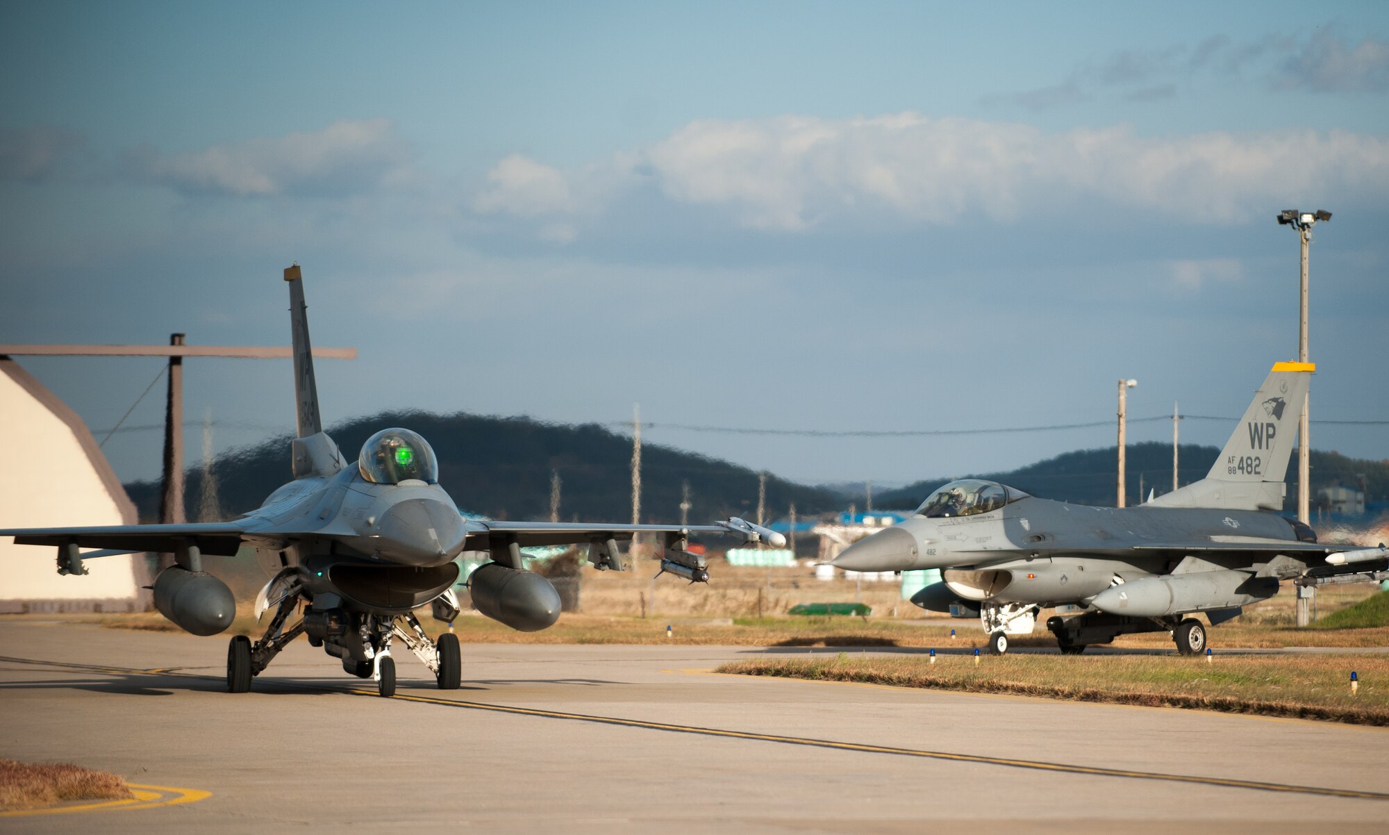 Two 80th Fighter Squadron F-16 Fighting Falcons taxis toward the runway for an exercise Beverly Bulldog 14-01 sortie at Kunsan Air Base, Republic of Korea, Nov. 20, 2013. Kunsan’s pilots and maintainers continued to launch F-16 Fighting Falcons during a simulated chemical environment. The base tested its ability to generate aircraft under simulated hostile field conditions. The Wolf Pack, along with other 7th Air Force units, continued performing its operational and tactical wartime missions during the peninsula-wide exercise Beverly Bulldog 14-01. (U.S. Air Force photo by Senior Airman Armando A. Schwier-Morales)