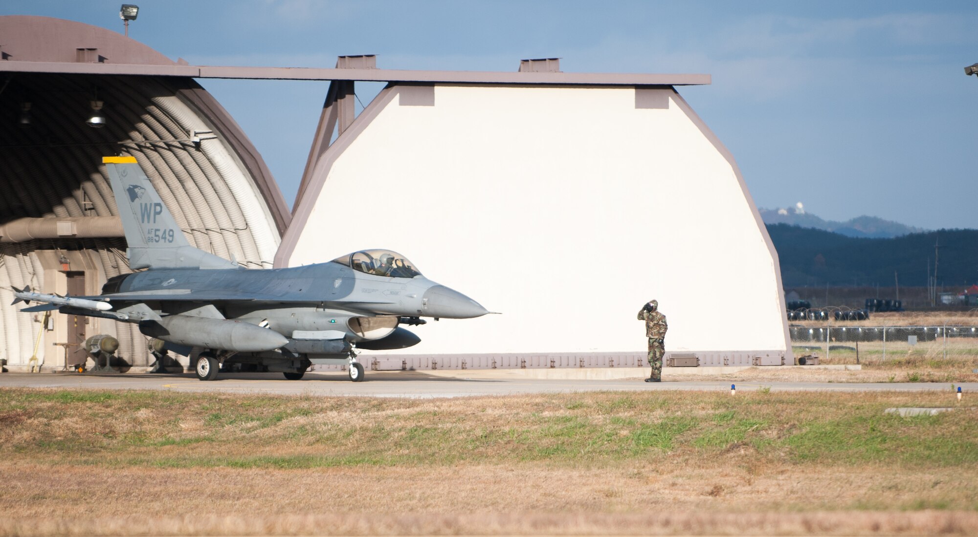 An 80th Fighter Squadron pilot and maintainer exchange salutes prior to taking off for a Beverly Bulldog 14-01 sortie at Kunsan Air Base, Republic of Korea, Nov. 20, 2013. Kunsan’s pilots and maintainers continued to launch F-16 Fighting Falcons during a simulated chemical environment. The base tested its ability to generate aircraft under simulated hostile field conditions. The Wolf Pack, along with other 7th Air Force units, continued performing its operational and tactical wartime missions during the peninsula-wide exercise Beverly Bulldog 14-01. (U.S. Air Force photo by Senior Airman Armando A. Schwier-Morales)