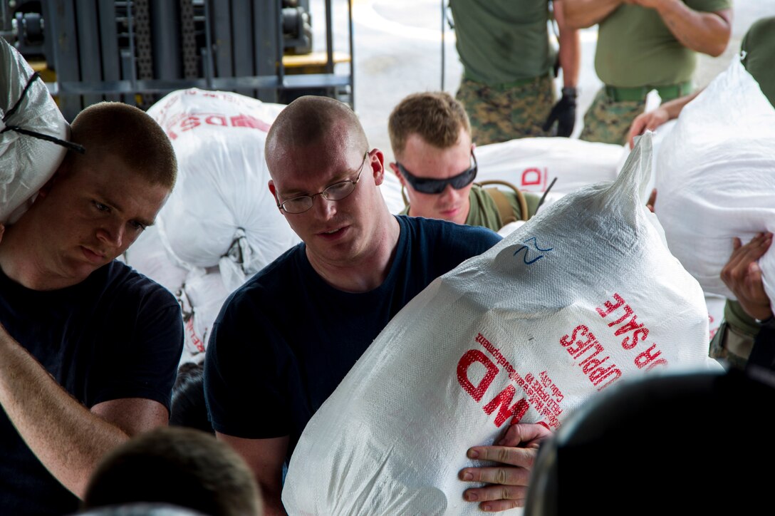 U.S. Navy Petty Officer  1st Class Robert Henderson, center, and other sailors assigned to the aircraft carrier USS George Washington and Marines assigned to the 3d Marine Expeditionary Brigade load boxes of supplies into a U.S. Marine Corps MV-22 Osprey from the Marine Medium Tiltrotor Squadron 262 to be airlifted to nearby villages in support of Operation Damayan in Tacloban, Philippines, Nov. 20, 2013. 