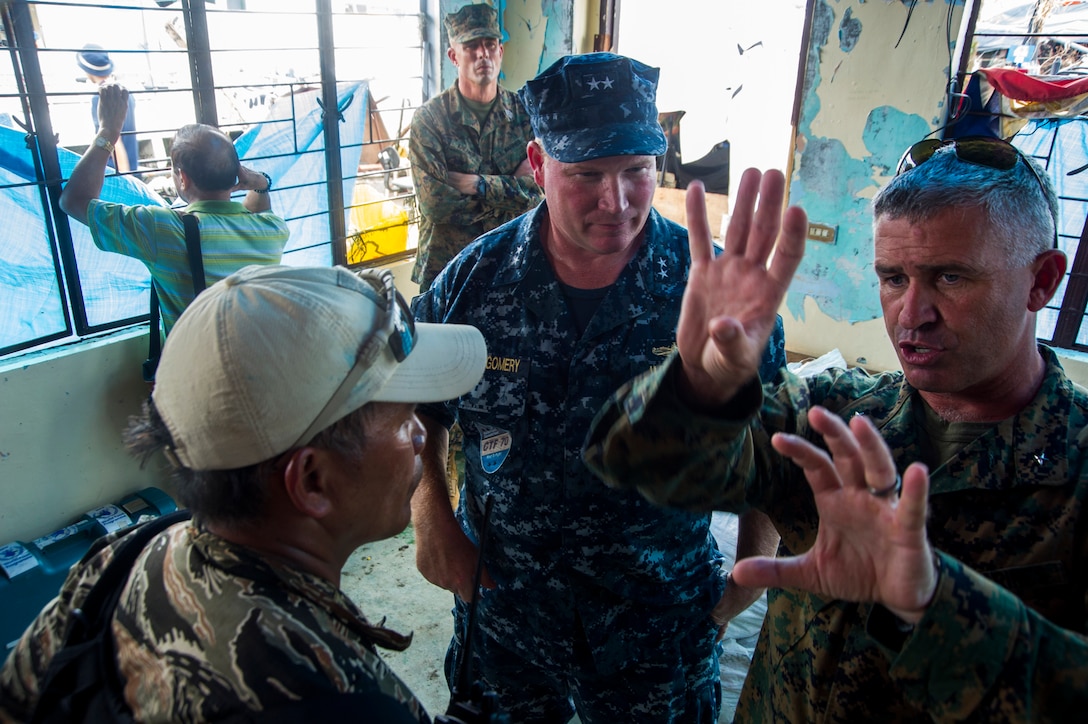 U.S. Marine Corps Brig. Gen. Paul Kennedy, right, commanding general of the 3rd Marine Expeditionary Brigade; U.S. Navy Rear Adm. Mark Montgomery, commander of Battle Force U.S. 7th Fleet; and Philippine navy Capt. Roy Vincent Trinidad, officer in charge, of Tacloban airfield, discuss support for Operation Damayan in Tacloban, Philippines, Nov. 20, 2013.