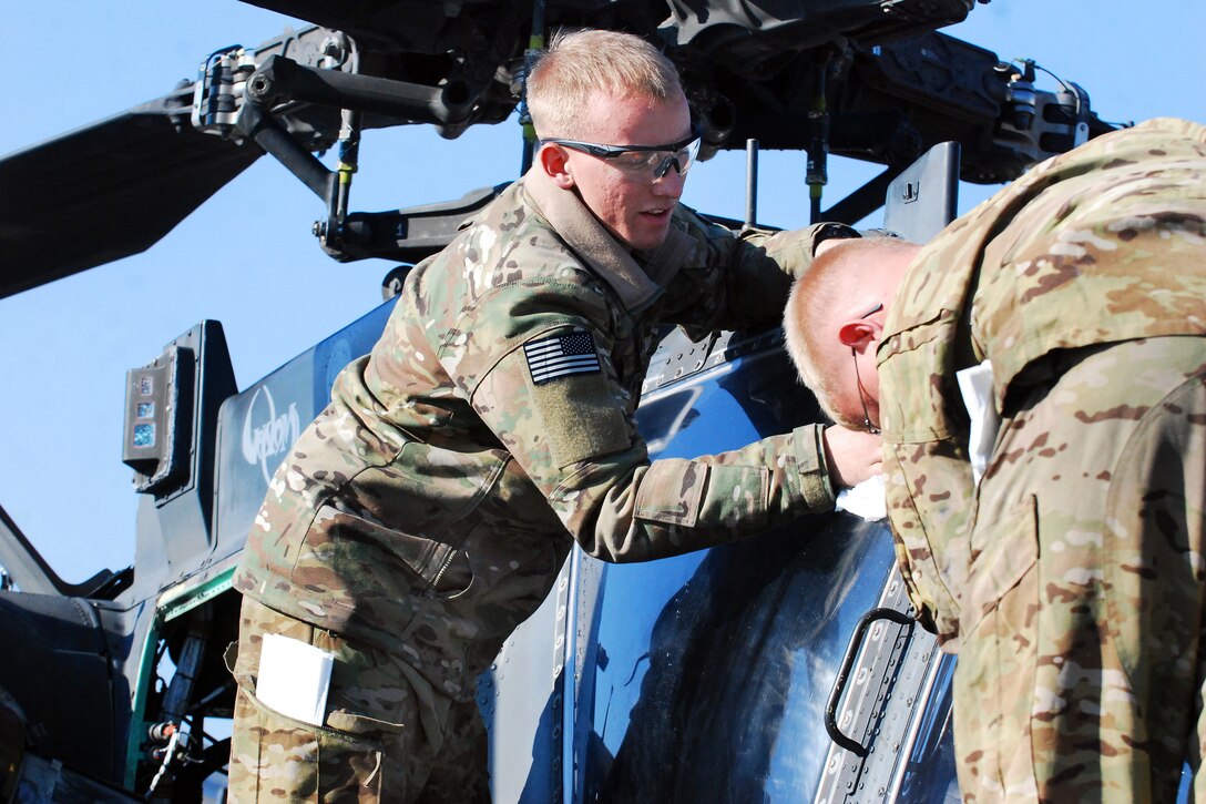 U.S. soldiers prepare an AH-64 Apache helicopter for flight before conducting a security and reconnaissance mission on Forward Operating Base Fenty, Afghanistan, Nov. 12, 2013.