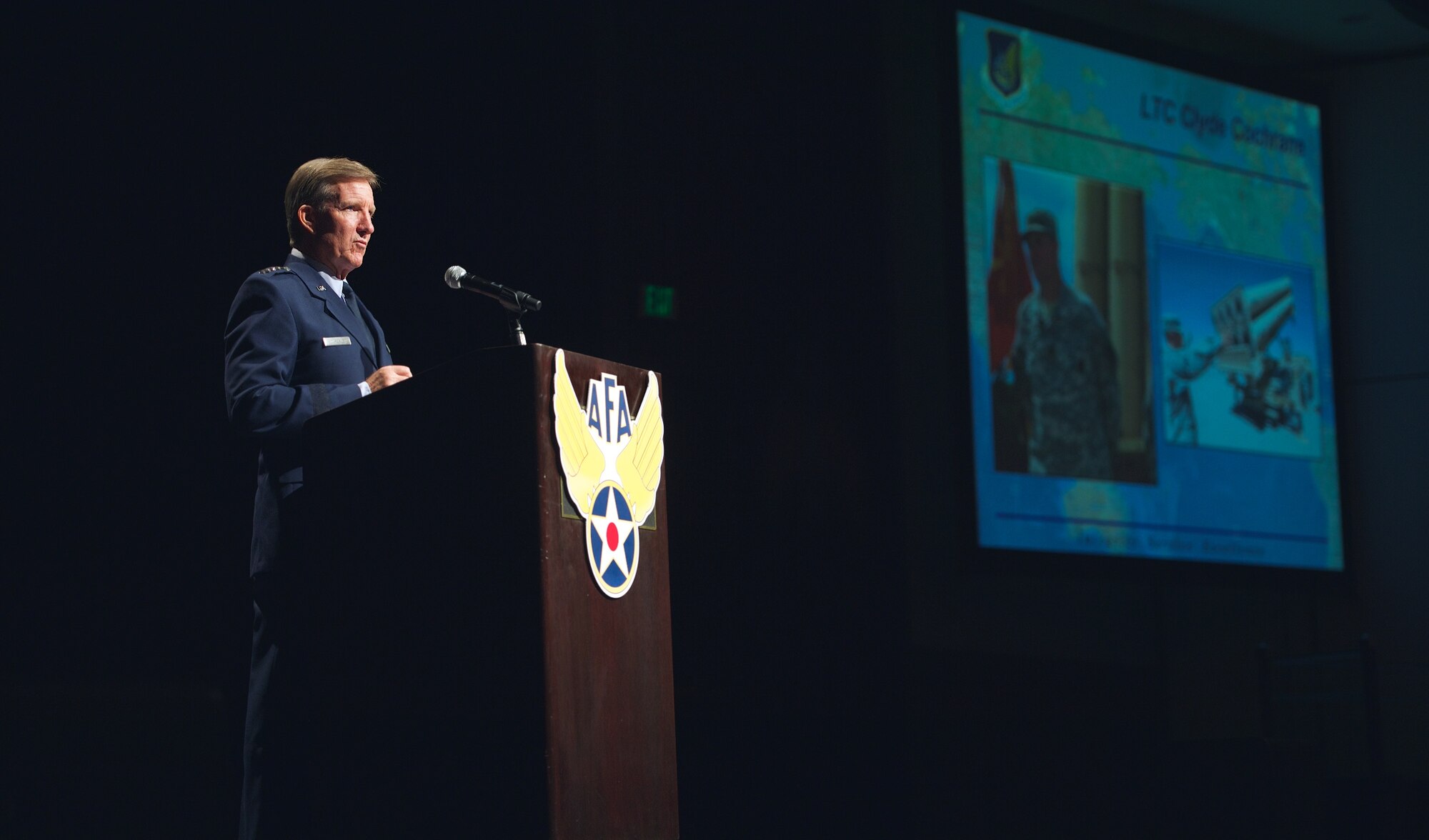 Gen. Hawk Carlisle speaks about the accomplishments of Lt. Col. Clyde Cochraine during his presentation Nov. 21, 2013, at the Air Force Association’s 2013 Pacific Air & Space Symposium held in Los Angeles, Calif. Carlisle focused on individual stories of Airmen under his command and their contributions to a shifting mission in the Asia-Pacific region. Carlisle is the commander of Pacific Air Forces. Cochraine is a U.S. Army air defender who contributed to Air Force integrated air and missile defense. 