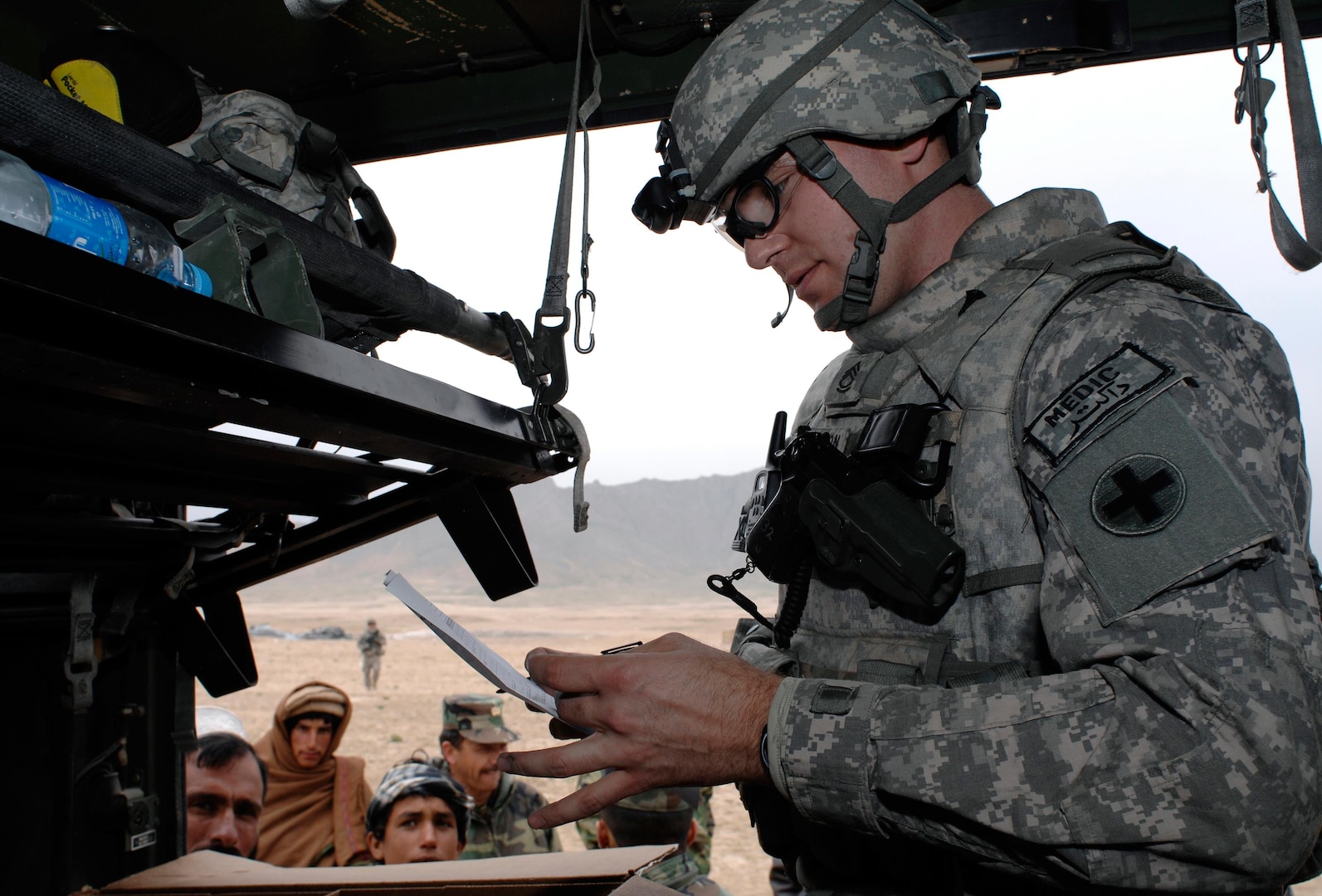 Sgt. 1st Class Aaron Christianson, Illinois Army National Guard's Headquarters and Headquarters Sustainment Brigade, 2nd Battalion, 122nd Field Artillery based in Chicago, reviews and fills prescriptions at Kuchi Village during their medical assistance visit April 5.