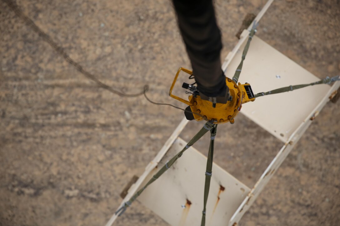 A model tank dangles from a single-point hook connected to a CH-53E Super Stallion during an external lift exercise aboard Marine Corps Base Camp Pendleton, Calif., Nov. 20. The connection between the model and single-point hook required collaboration between Marines in the Super Stallion and Marines with Combat Logistics Regiment 17 on the ground.