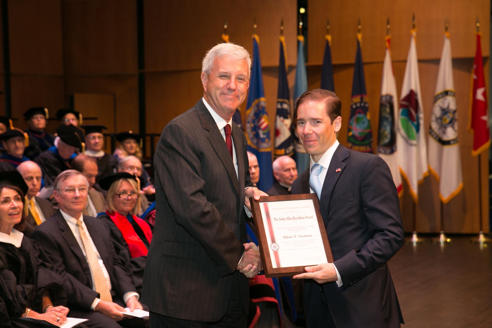 RADM James McPherson (USN, JAGC, Ret.) presents Adam Pearlman the first Judge Allan Kornblum Award for Best Student Thesis in National Security Law and Ethics during NIU's commencement in July. The award honors the achievements of Judge Kornblum, a noted Justice Department official and federal judge.