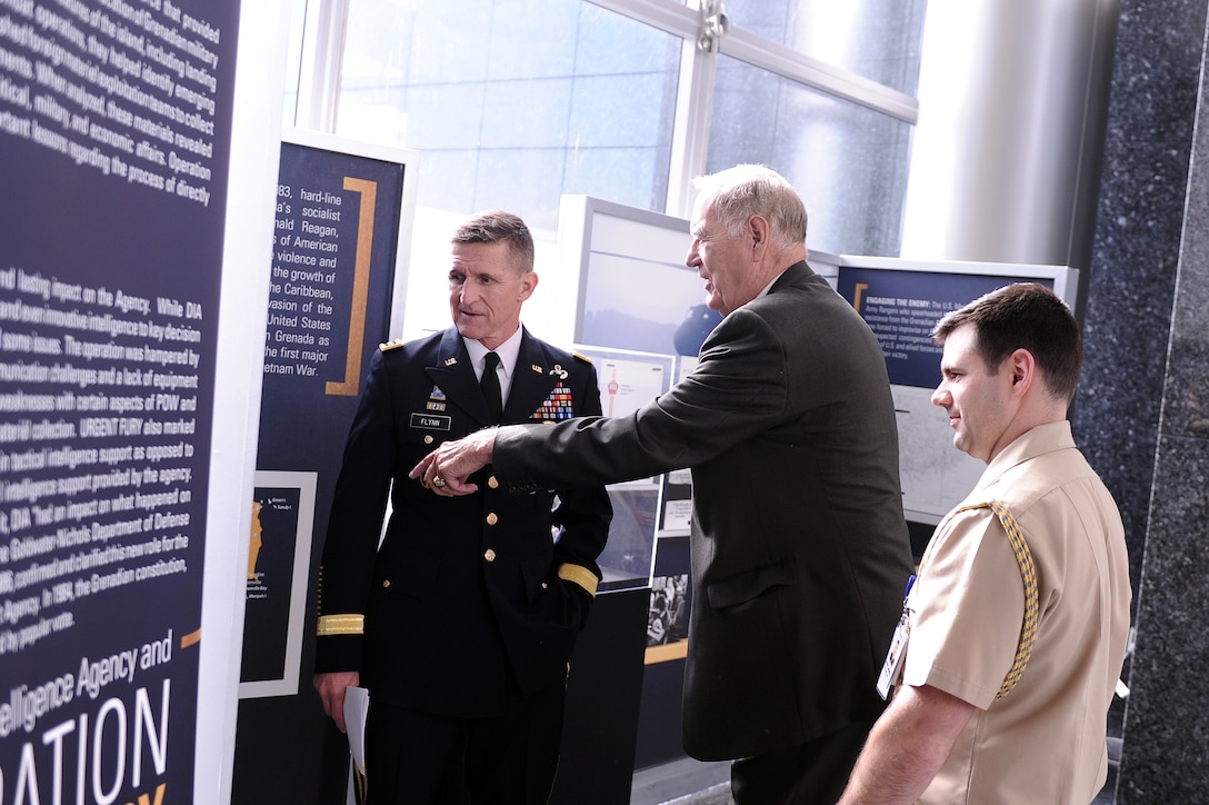 From left, current Director LTG Michael Flynn, former director LTG James Williams, and the director’s executive officer discuss the Operation Urgent Fury display in the Missile Lobby after the event. 