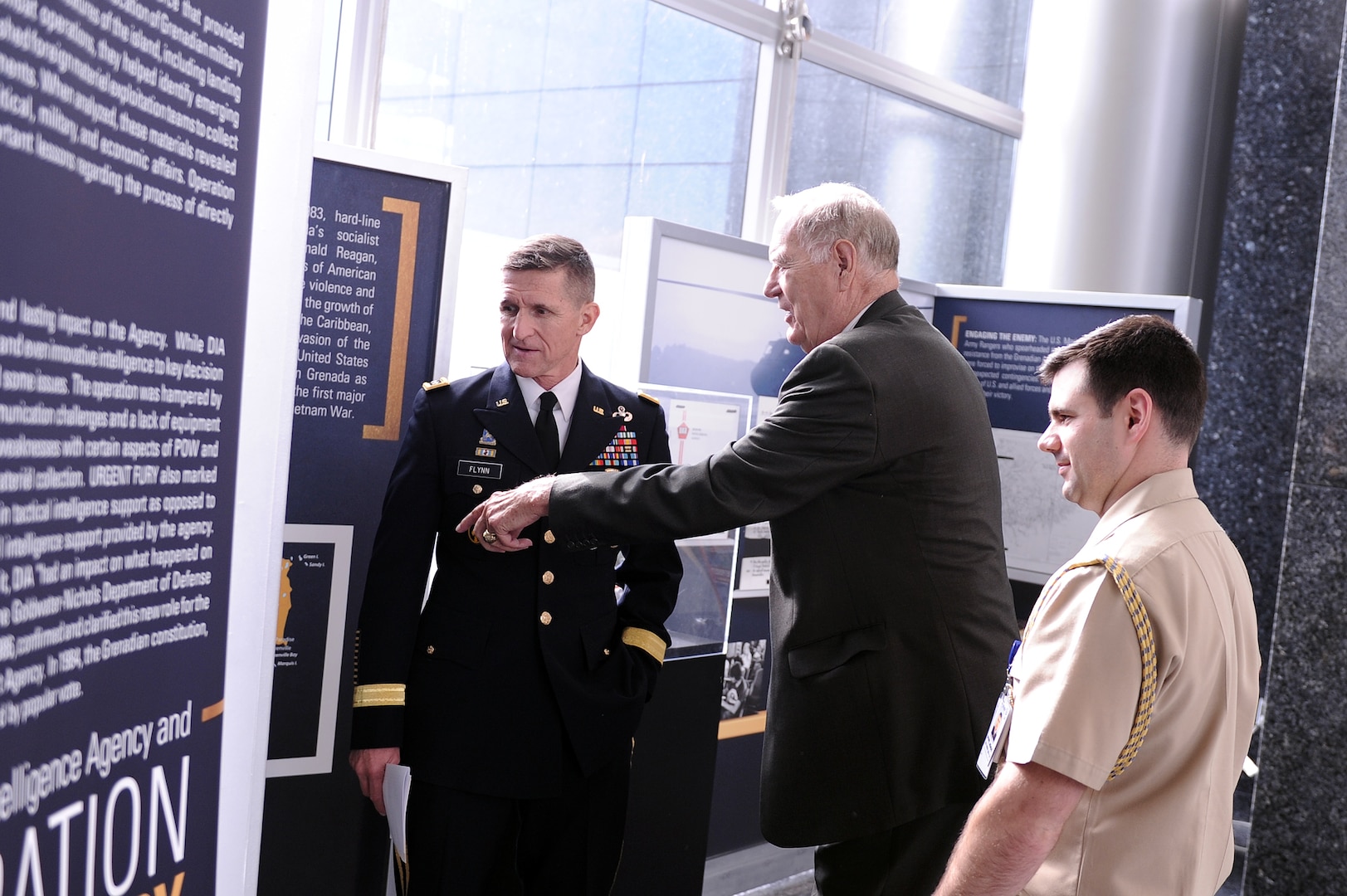 From left, current Director LTG Michael Flynn, former director LTG James Williams, and the director’s executive officer discuss the Operation Urgent Fury display in the Missile Lobby after the event. 