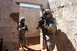 Pfc. Jack Shaw, front, and Sgt. Michael Ring, both assigned to C Company, 2nd Battalion, 127th Infantry Regiment, encounter a threat as they enter a building during urban-operations training Saturday at McGregor Range, N.M.