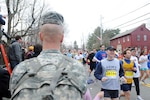 Army Chief Warrant Officer Thomas R. Lamont, a military personnel technician with Headquarters Company, 26th Maneuver Enhancement Brigade wears an Army t-shirt as he runs past Sgt. Brian L. McClelland in Hopkinton, Mass., during the 113th running of the Boston Marathon April 20, 2009. Lamont finished the marathon with a time of 4 hours 47 minutes.