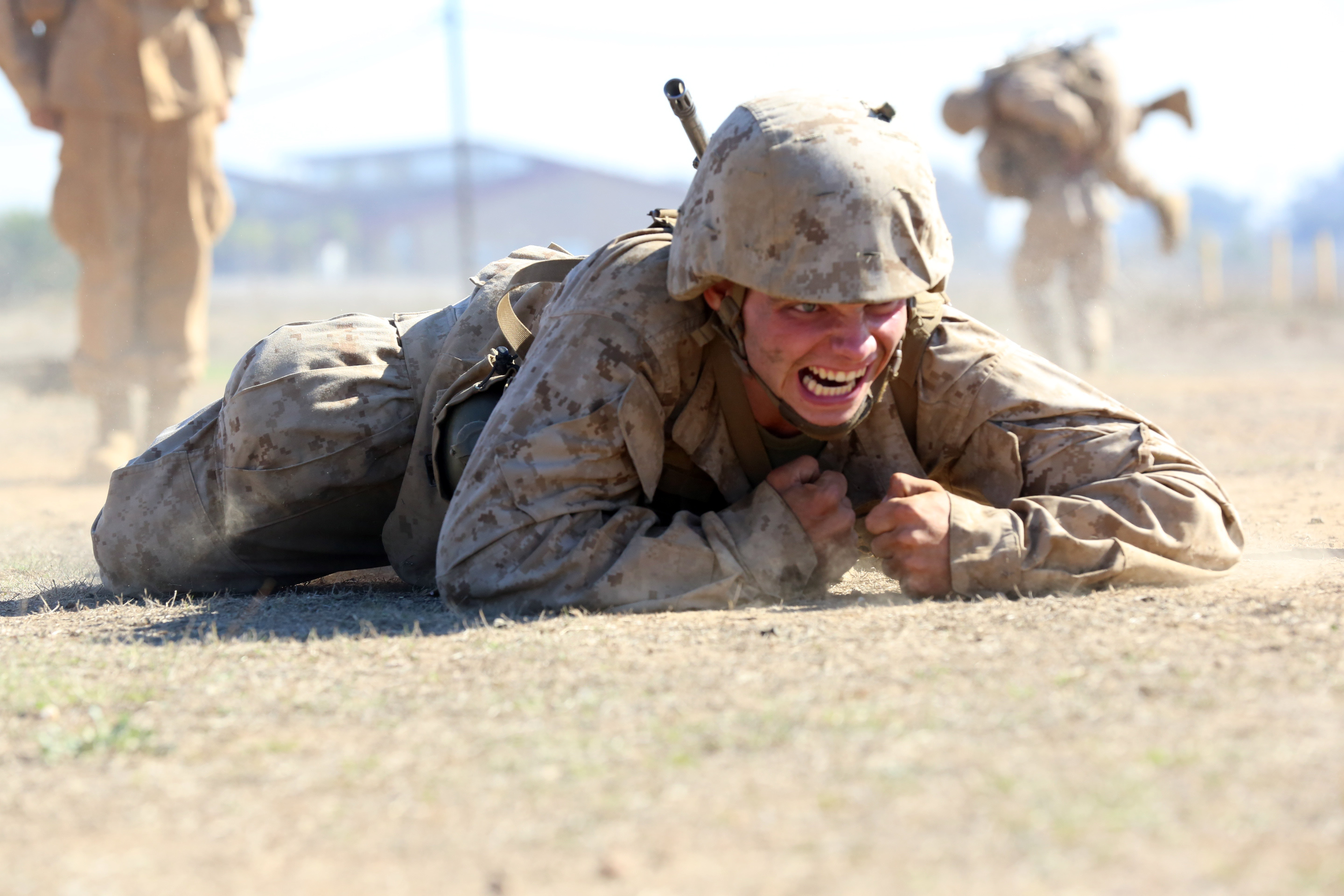 Pvt. Daniel R. Toman, Platoon 3201, Co. I, 3rd Recruit Training Battalion, low-crawls after throwing a simulated grenade during the Crucible at Edson Range aboard Marine Corps Base Camp Pendleton, Calif., Nov. 13.