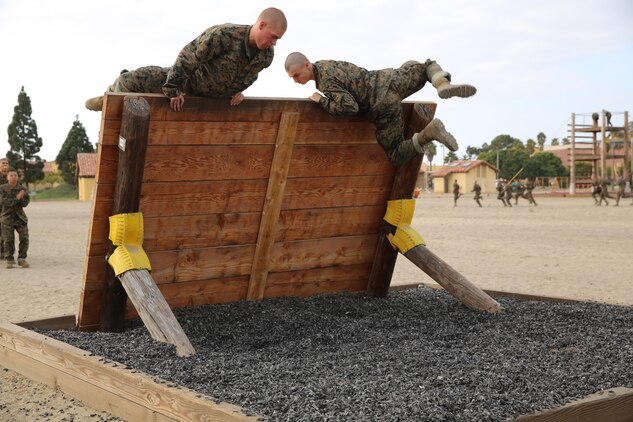 Recruits climb their way up and over a wall while running the Confidence Course, Nov. 4. If a recruit failed any part of an obstacle, drill instructors sent him back to the beginning to try again.