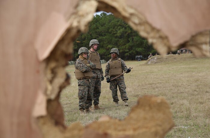 Marines with Improved Ribbon Bridge Platoon, 8th Engineer Support Battalion, 2nd Marine Logistics Group review the wreckage left by door-breaching explosives during a demolition training exercise aboard Camp Lejeune, N.C., Nov. 20, 2013. The breaching allowed the members of IRB Plt. to see first-hand how to employ the different types of explosives and the capabilities of each one. 