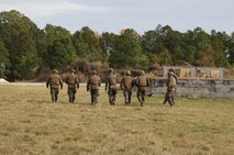 Marines with Improved Ribbon Bridge Platoon, 8th Engineer Support Battalion, 2nd Marine Logistics Group walk downrange to place explosive charges during a demolition training exercise aboard Camp Lejeune, N.C., Nov. 20, 2013. The Marines used field-constructed explosives such as grapeshot, plate charges and water charges to train for urban combat operations in future deployments. 