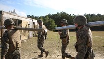 Marines with Improved Ribbon Bridge Platoon, 8th Engineer Support Battalion, 2nd Marine Logistics Group carry expedient Bangalore torpedoes used for path-clearing operations during a demolition training exercise aboard Camp Lejeune, N.C., Nov. 20, 2013. The explosives used by the platoon were assembled in the field from C-4, detonation cord and materials readily available in an urban combat zone.