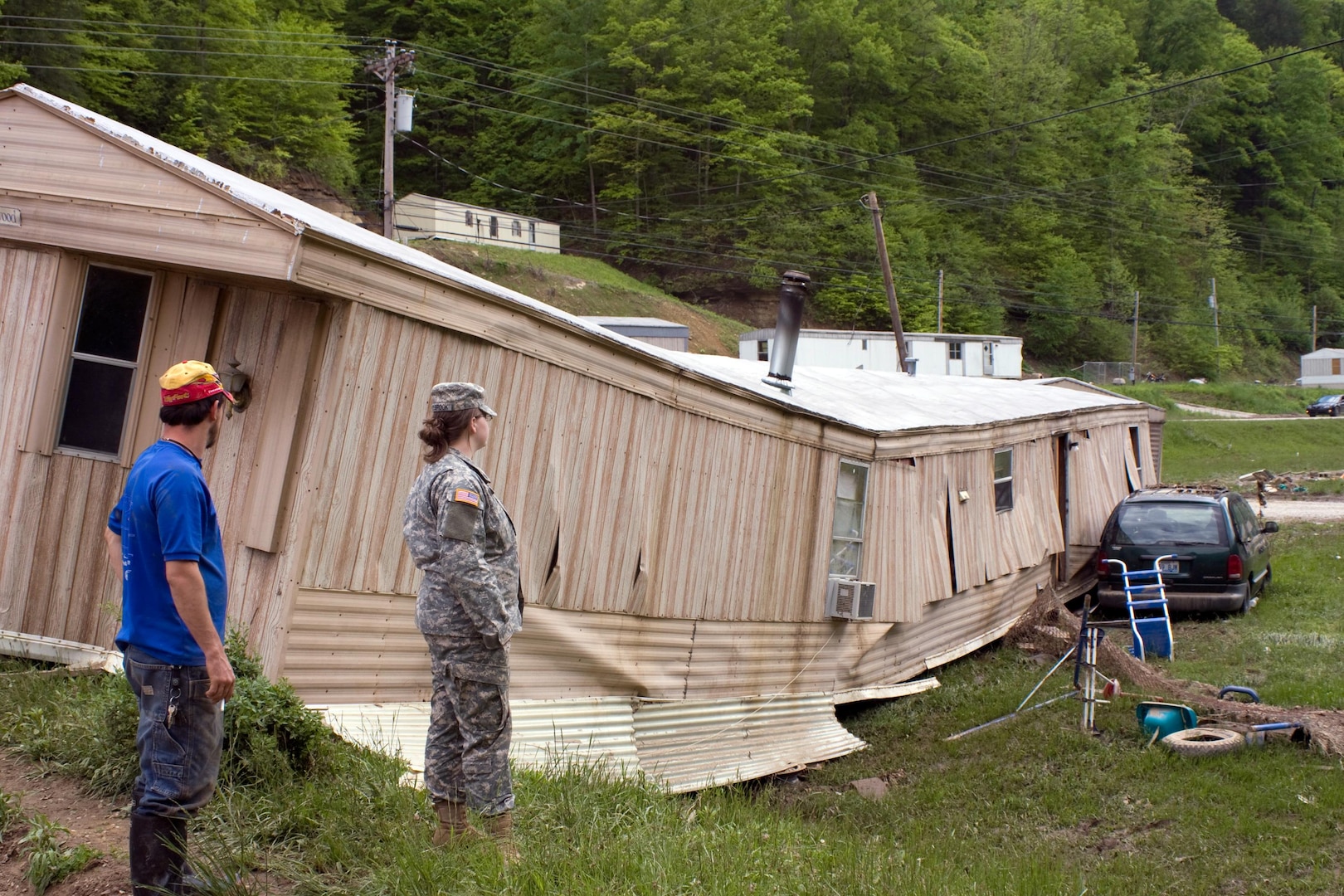 Breathitt County, Ky. resident Jeffrey Johnson (left) surveys the remains of his mobile home with Army Spec. Deborah Holbrook, Det. 1, 207th Engineer Co., following flash flooding that swept through Jackson, Ky, on Saturday, May 9, 2009.