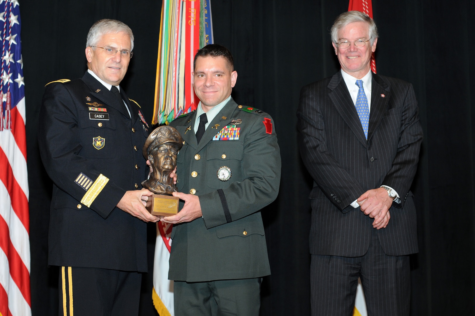Army Chief of Staff Gen. George W. Casey Jr. presents the MacArthur Award to Capt. Cliff A. Morales from the Pennsylvania Army National Guard during a Pentagon ceremony Friday as the MacArthur Foundation's Henry Harris III observes the presentation.