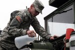 Private Justin Bean of Tazewell adds water to the coolant system of a 5-ton dump truck May 17 in preparation for a convoy movement to West Virginia. The Virginia National Guard's 1033rd Engineer Company based in Cedar Bluff, Va., departed May 18 to assist with debris removal and flood recovery in West Virginia. The unit is scheduled to be on duty for up to 30 days.