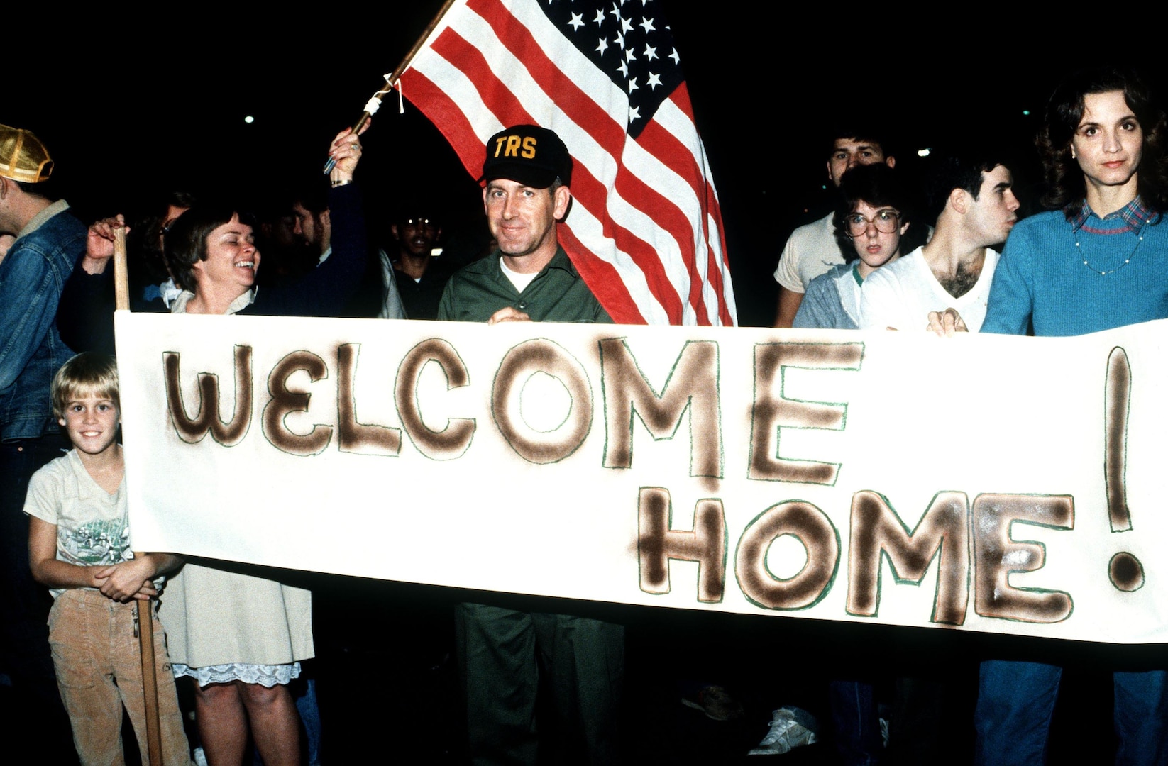 Friends and family hold up a “Welcome Home” sign for the American medical students arriving at Charleston Air Force Base Nov. 3, 1983, after being rescued in Grenada by U.S. forces. 