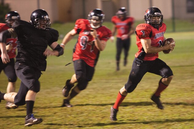 Justin Longoria, Bandits' quarterback, scrambles to avoid Spartans' players during a football game at Riseley Field, Nov, 19, 2013. (U.S. Marine Corps photo by Lance Cpl. Nathan Knapke) 