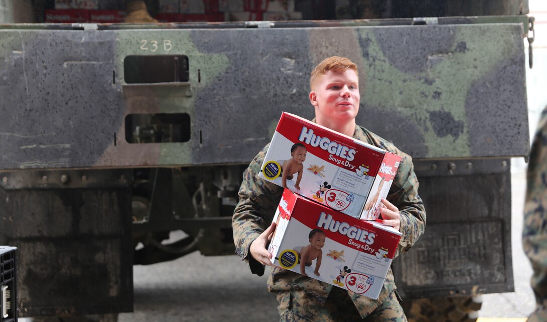 Lance Cpl. Alexander Williams, a supply administrative specialist with the 11th Marine Expeditionary Unit, helps other MEU personnel distribute diaper boxes here Nov. 21. Huggies donated 150,000 diapers to nine different units within Camp Pendleton as a gesture of appreciation for military service.     