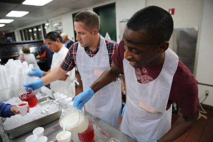 Joshua P. Davis, left, Single Marine Program coordinator and Petty Officer 3rd Class Thomas Meredith, Yoeman, serve drinks to clients at the Saint Vincent De Paul’s homeless shelter, Nov. 11. 