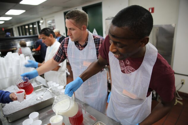 Joshua P. Davis, left, Single Marine Program coordinator and Petty Officer 3rd Class Thomas Meredith, Yoeman, serve drinks to clients at the Saint Vincent De Paul’s homeless shelter, Nov. 11. 