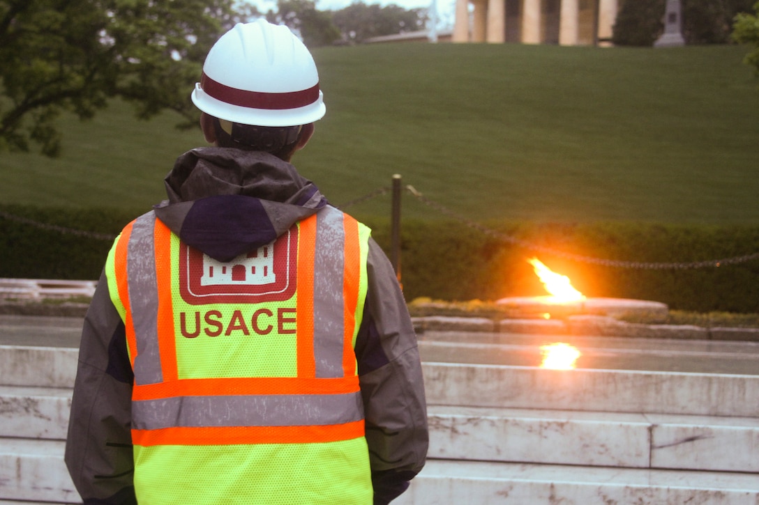 Nicholas Backert, a Norfolk District project engineer, looks at the President John F. Kennedy Eternal Flame at Arlington National Cemetery before contractors instal white fencing to block the public’s view of the site April 29, 2013. Repairs and upgrades to the flame include installing burners, an igniter, and new gas and air lines. Contractors estimate that work on the burner itself will take three weeks.