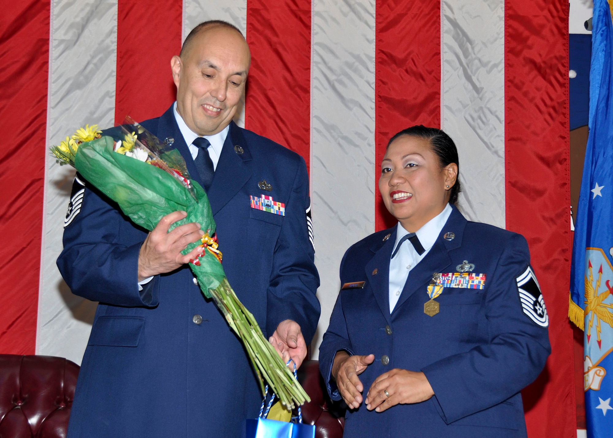 TRAVIS AIR FORCE BASE, Calif. -- Master Sgt. Robert Topete, 55th Aerial Port Squadron, attaches a retirement pin to his wife's lapel, Senior Master Sgt. Dahlia Topete, on the occasion of her retirement from the U.S. Air Force Reserve Nov. 16, 2013, at Travis Air Force Base, Calif. (U.S. Air Force photo by Tech. Sgt. Rachel Martinez/Released)