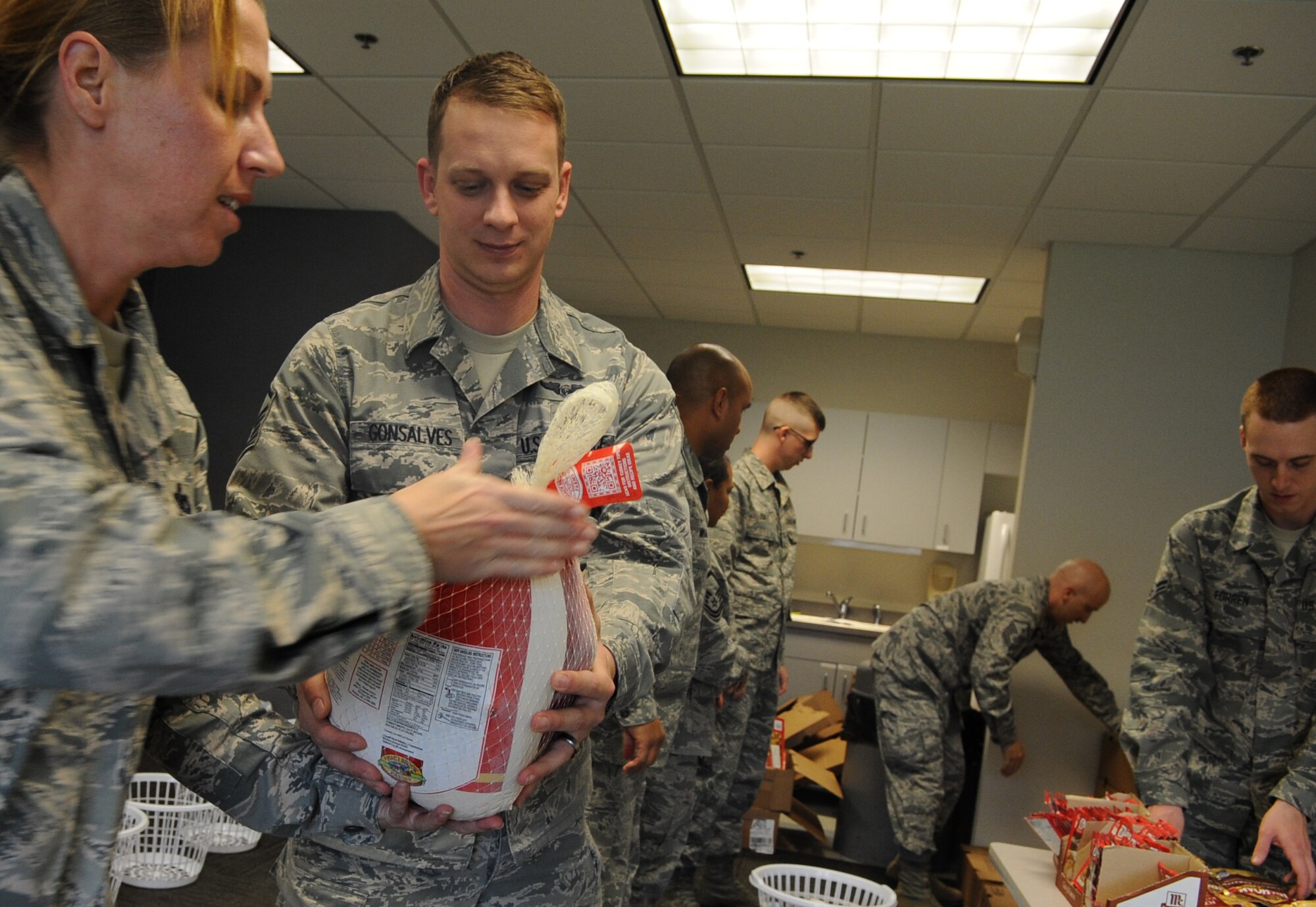 Master Sgt. Marc Gonsalves, 9th Airlift Squadron first sergeant, helps prepare 107 baskets of food for Thanksgiving meals for Airmen in need Nov. 21, 2013, at Dover Air Force Base, Del. The 436th Airlift Wing First Sergeants Council partnered with Dover Federal Credit Union to provide Thanksgiving baskets to 107 Airmen that included a turkey, stuffing, vegetables, rolls and many other items. (U.S. Air Force photo/Staff Sgt. Elizabeth Morris)