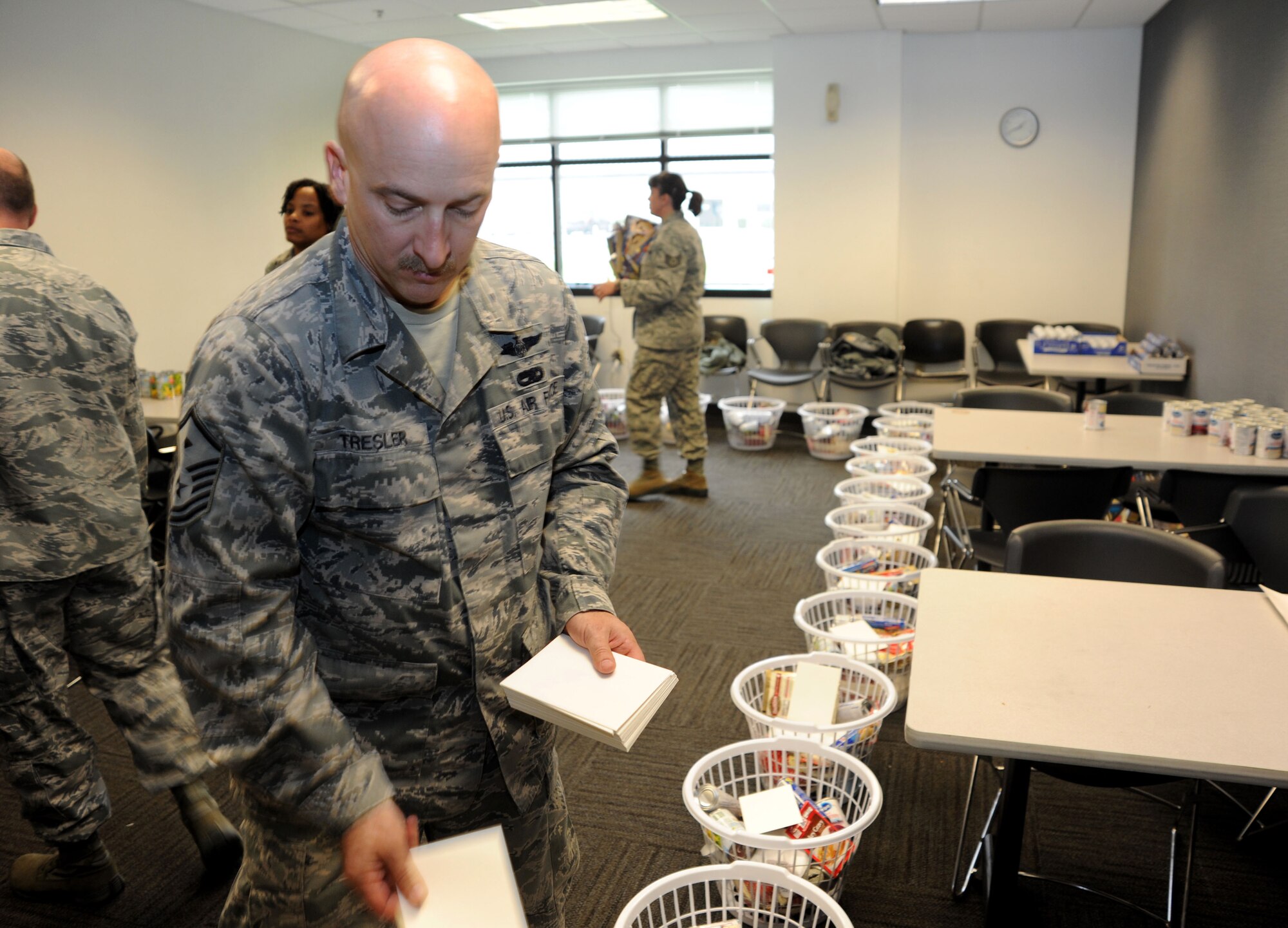 Master Sgt. Don Tresler, 436th Logistics Readiness Squadron first sergeant, places thank you cards in Thanksgiving baskets Nov. 21, 2013, at Dover Air Force Base, Del. Tresler is a member of the 436th Airlift Wing First Sergeants Council, who partnered with Dover Federal Credit Union to put together the baskets for Dover Airmen in need. (U.S. Air Force photo/Airman 1st Class Zachary Cacicia)