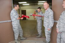 Col. Jeffrey Pennington, left, applauds the ribbon-cutting of the new Consolidated Tool Crib Nov. 21 as Col. Charles Combs, right, looks on.  The Crib opened for business after six months of renovation that included upgrading of heating and air-conditioning systems and replacement of all windows.