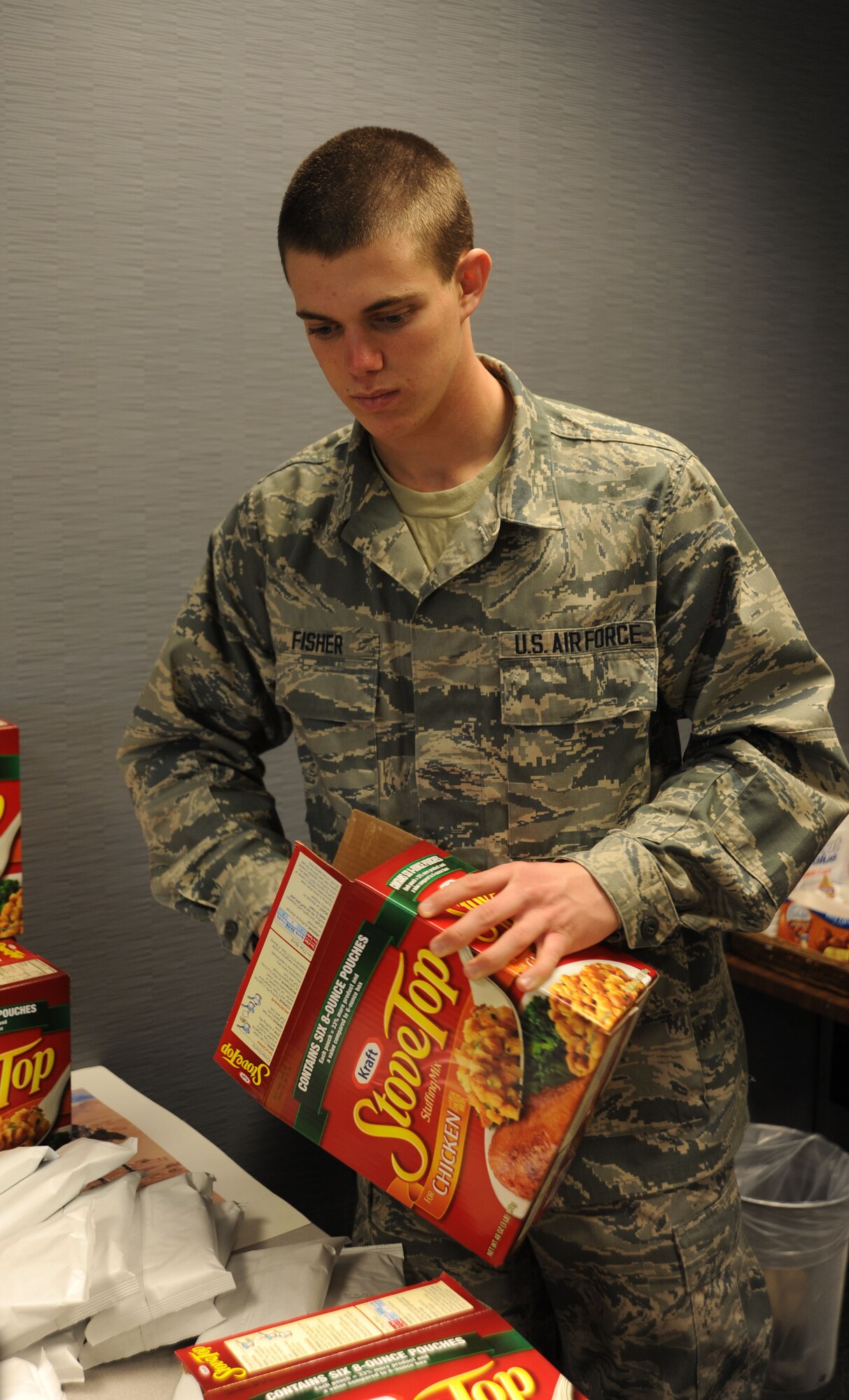 Airman Steven Fisher, 373rd Training Squadron Detachment 3, unpacks a box of Stove Top stuffing, Nov. 21, 2013, at Dover Air Force Base, Del. Fisher is assisting the 436th Airlift Wing First Sergeants Council, who partnered with Dover Federal Credit Union to provide Thanksgiving baskets to Airmen in need. (U.S. Air Force photo/Airman 1st Class Zachary Cacicia)