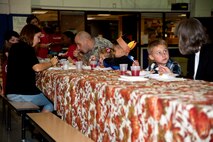 Parents and children share a meal at the youth center’s Thanksgiving celebration on Hurlburt Field, Fla., Nov. 21, 2013. To put everyone in the Thanksgiving spirit, the youth center also displayed holiday cartoons on a big screen. (U.S. Air Force photo/Senior Airman Michelle Vickers) 
