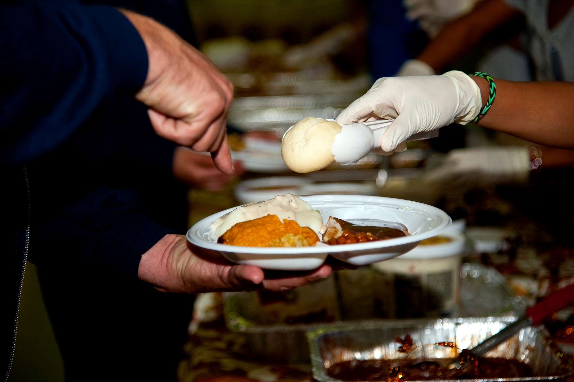 A volunteer serves food at the youth center’s Thanksgiving dinner at Hurlburt Field, Fla., Nov. 21, 2013. The meal provided an opportunity for parents, their children and youth center staff to come together and celebrate the holiday. (U.S. Air Force photo/Senior Airman Michelle Vickers)