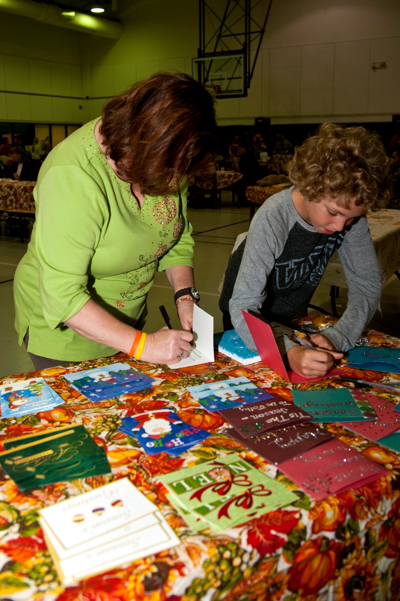 Debbie Wardencki and her son David Wardencki, 10, write holiday greetings for deployed service members during the youth center’s Thanksgiving dinner on Hurlburt Field, Fla., Nov. 21, 2013. The meal provided an opportunity for parents, their children and youth center staff to come together and celebrate the holiday. (U.S. Air Force photo/Senior Airman Michelle Vickers) 