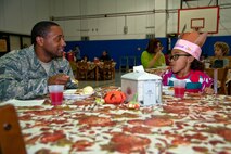 Staff Sgt. Jamar Maule, 1st Special Operations Logistics Readiness Squadron fuels system craftsman, and his daughter, Maja Maule, 7, eat together during the youth center’s Thanksgiving dinner on Hurlburt Field, Fla., Nov. 21, 2013. The meal provided an opportunity for parents, their children and youth center staff to come together and celebrate the holiday. (U.S. Air Force photo/Senior Airman Michelle Vickers)
