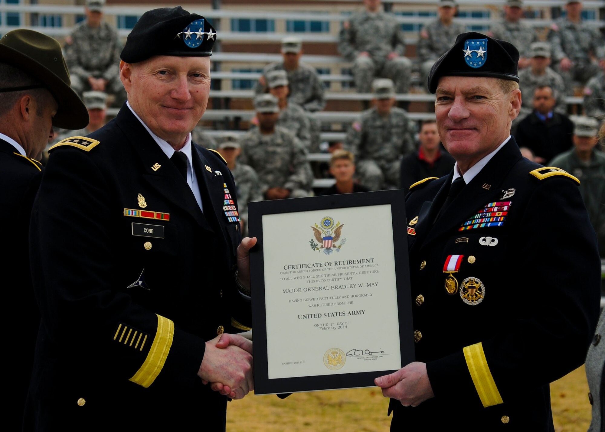 From left, U.S. Army Gen. Robert Cone, Training and Doctrine Command commanding general, presents Maj. Gen. Bradley May, former Initial Military Training Center of Excellence deputy commanding general, his certificate of retirement during a change of responsibility and retirement ceremony at Fort Eustis, Va., Nov. 22, 2013. Maj. Gen. Ross Ridge will replace May as the IMT deputy commanding general. (U.S. Air Force photo by Airman 1st Class Austin Harvill/Released)