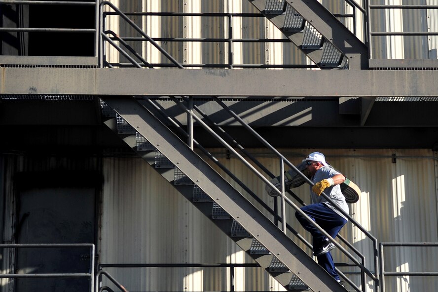A member of Team Seymour carries a fire hose up three flights of stairs during the firefighter challenge at Seymour Johnson Air Force Base, N.C., Nov. 22, 2013.  The 4th Fighter Wing promoted the physical pillar of the Comprehensive Airman Fitness program by hosting multiple athletic events featuring representatives from several squadrons. (U.S. Air Force photo by Tech. Sgt. Brittany E. Jones)