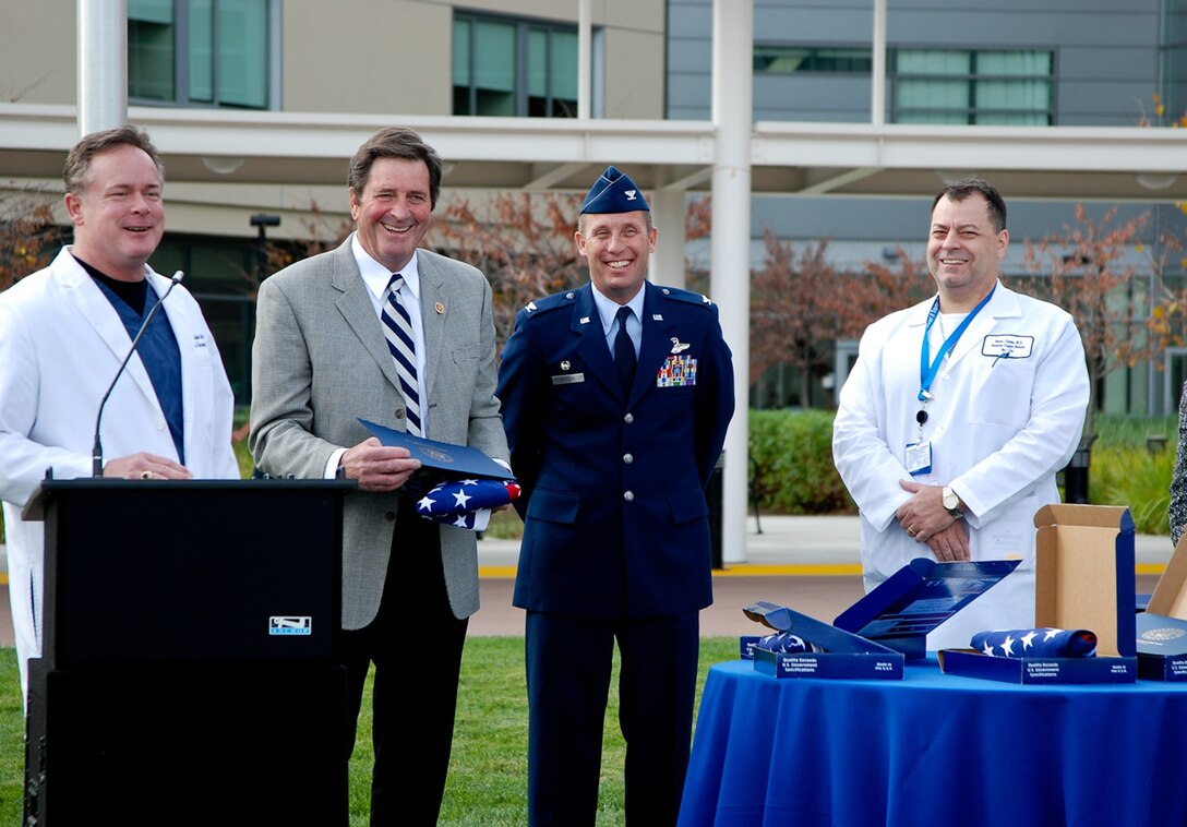 TRAVIS AIR FORCE BASE, Calif. -- Kaiser Permanente Medical Center, Vacaville, Calif., honored their veterans and reservists Nov. 11, 2013, with a special ceremony on the front lawn. Among those being honored were Lt. Col. Chris Bandy, Trauma Medical director and Air Force Reservist with the 349th Medical Squadron at Travis Air Force Base. Attending to honor the veterans were Congressman John Garamendi and Bandy's boss and Commander of the 349th Air Mobility Wing, Col. Matt Burger. Garamendi presented flags flown over the U.S. Capitol to Bandy and three other physicians who are veterans. (Photo courtesy of Kaiser Permanente)